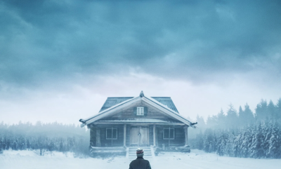 A person walking towards a house in the snow